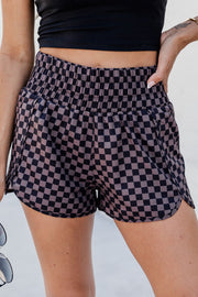 Elastic waist checkerboard running shorts in plaid with side slits.