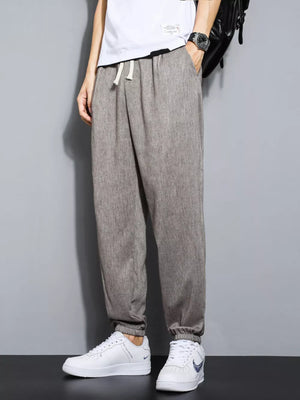 Men's grey relaxed fit drawstring sweatpants with ankle cuffs.