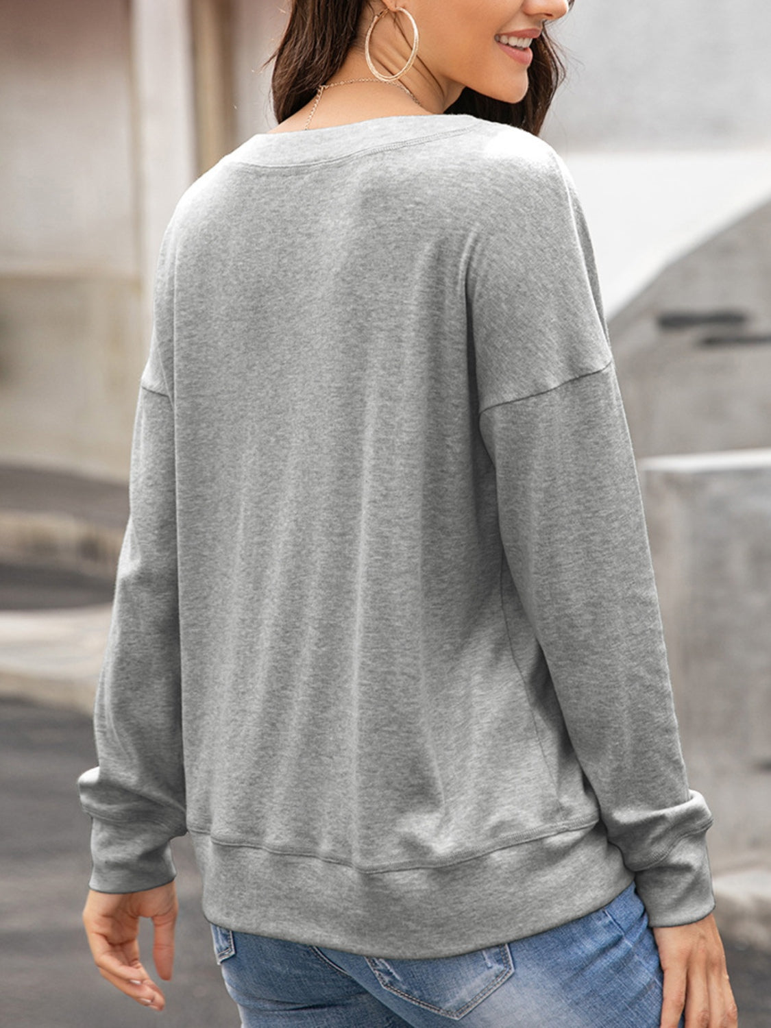 Gray crewneck sweatshirt with drop shoulders and long sleeves.