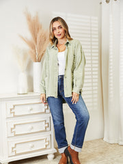 Light green distressed denim overshirt with raw hem and button front.