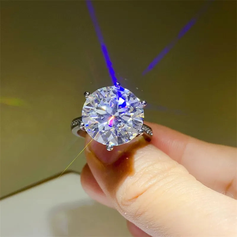 Silver solitaire ring with a large, round-cut diamond and smaller stones on the band.