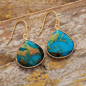 Teardrop turquoise and gold dangle earrings with unique blue and brown patterns.