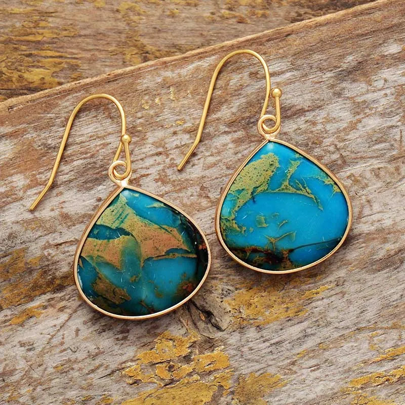 Teardrop turquoise and gold dangle earrings with unique blue and brown patterns.