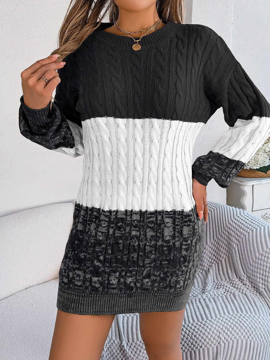 Colorblock cable knit mini dress with crew neck and long sleeves in black, white, and grey.