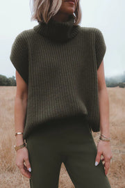 Sleeveless ribbed turtleneck sweater in army green acrylic, styled casually.
