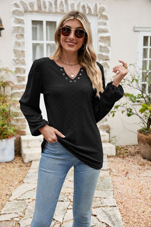 Black eyelet yoke blouse with blouson sleeves and V-neckline.
