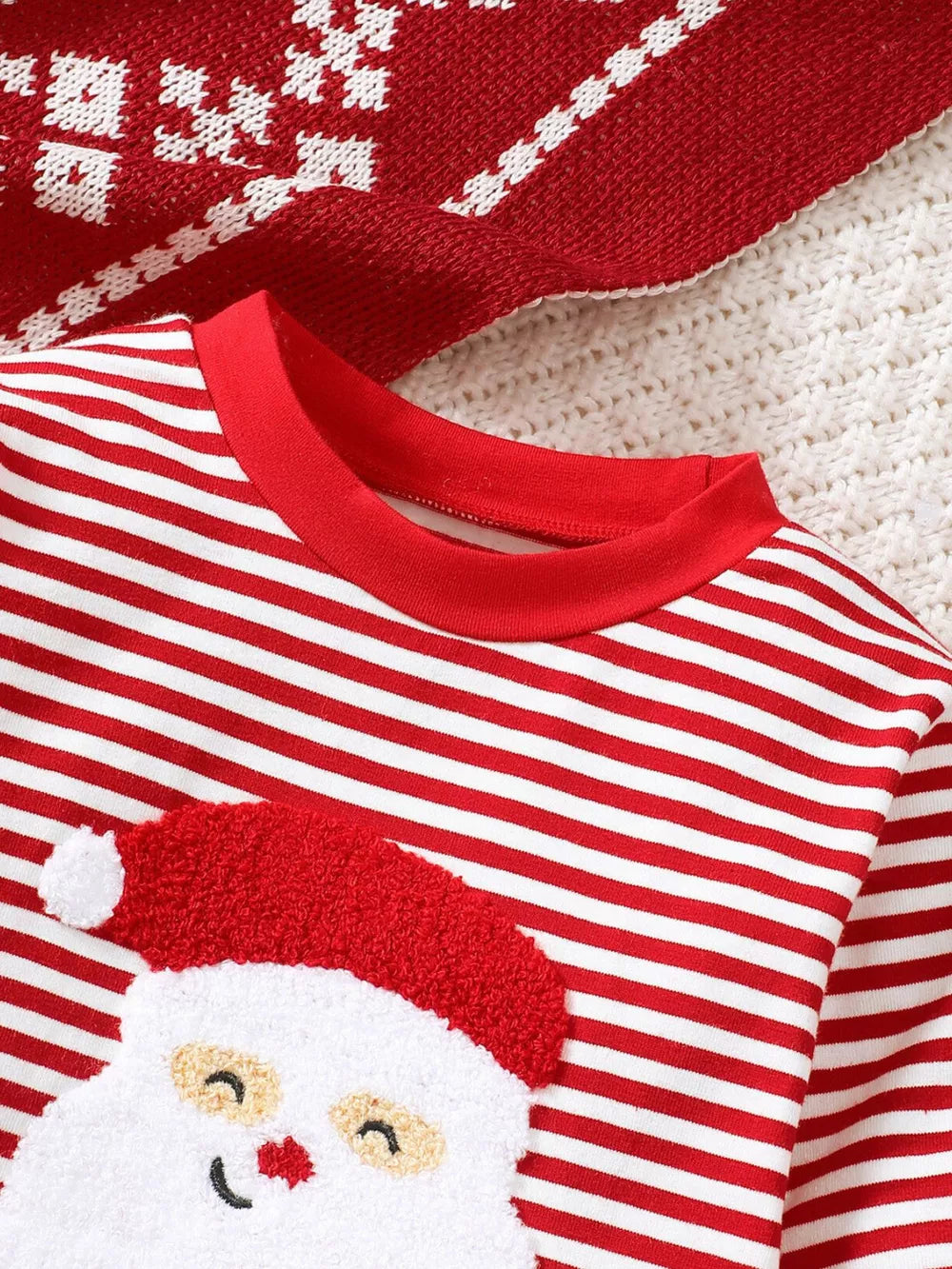 Baby red and white striped Santa pajama top with applique Santa face detail.