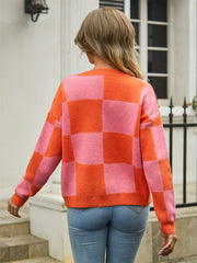Checkerboard knit cardigan in orange and pink with crew neck and long sleeves.