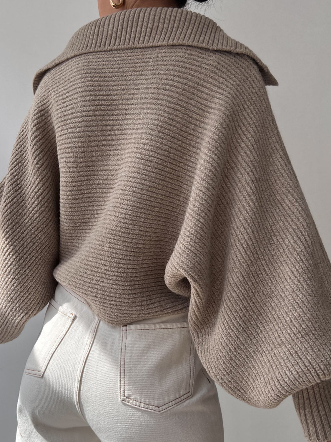 Tan knit sweater with wide collar and balloon sleeves, ribbed texture.