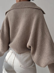 Tan knit sweater with wide collar and balloon sleeves, ribbed texture.