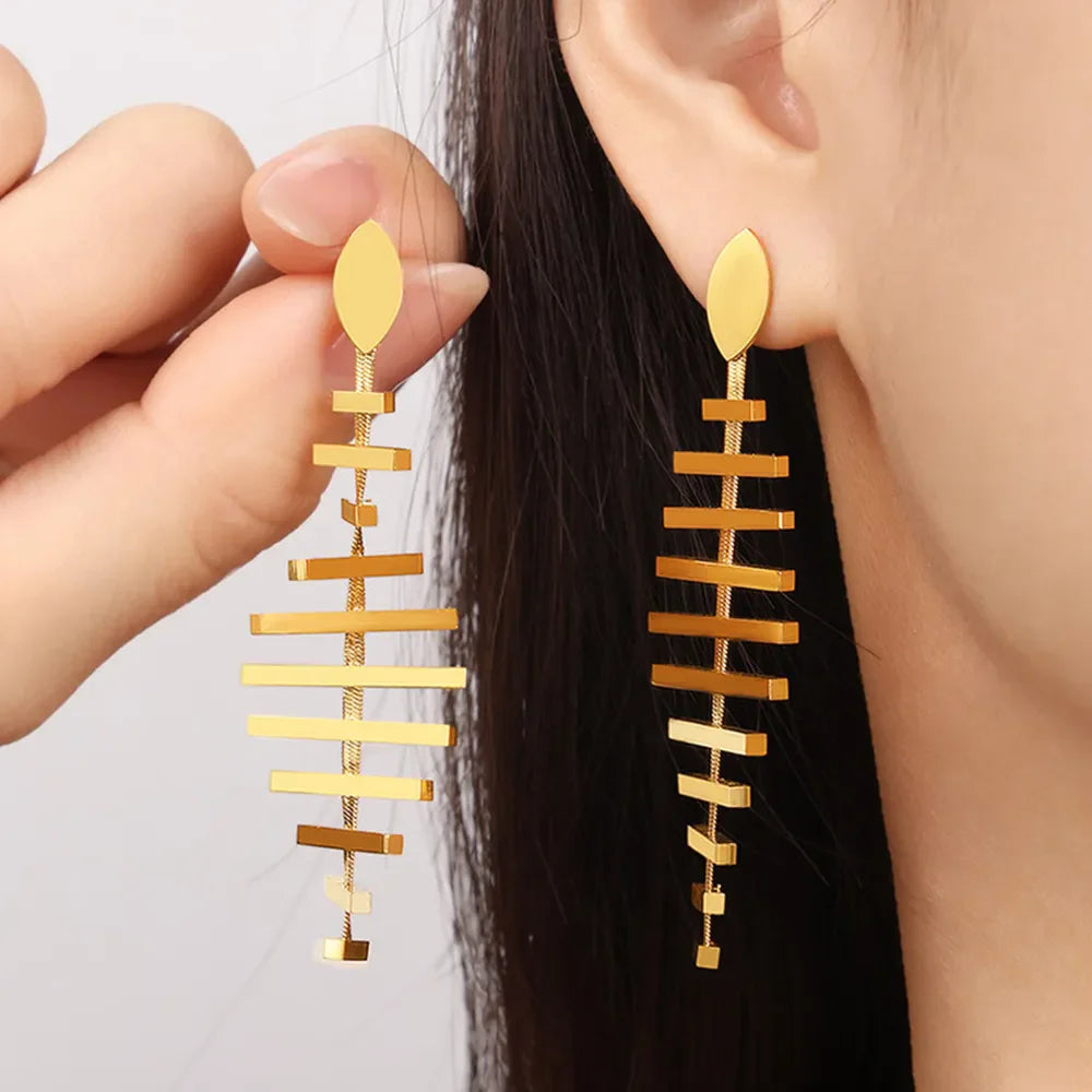 Geometric steel fishbone drop earrings in gold, featuring a modern layered design.