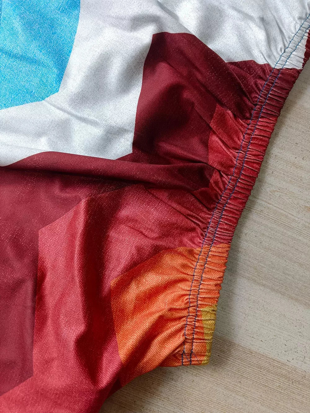 Asymmetrical top and slit skirt ensemble with abstract geometric print in red, white, and blue.