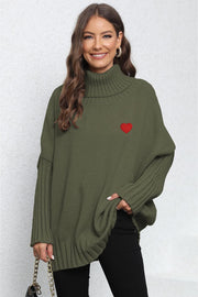 Army green batwing knit turtleneck sweater with red heart embroidery and ribbed details.