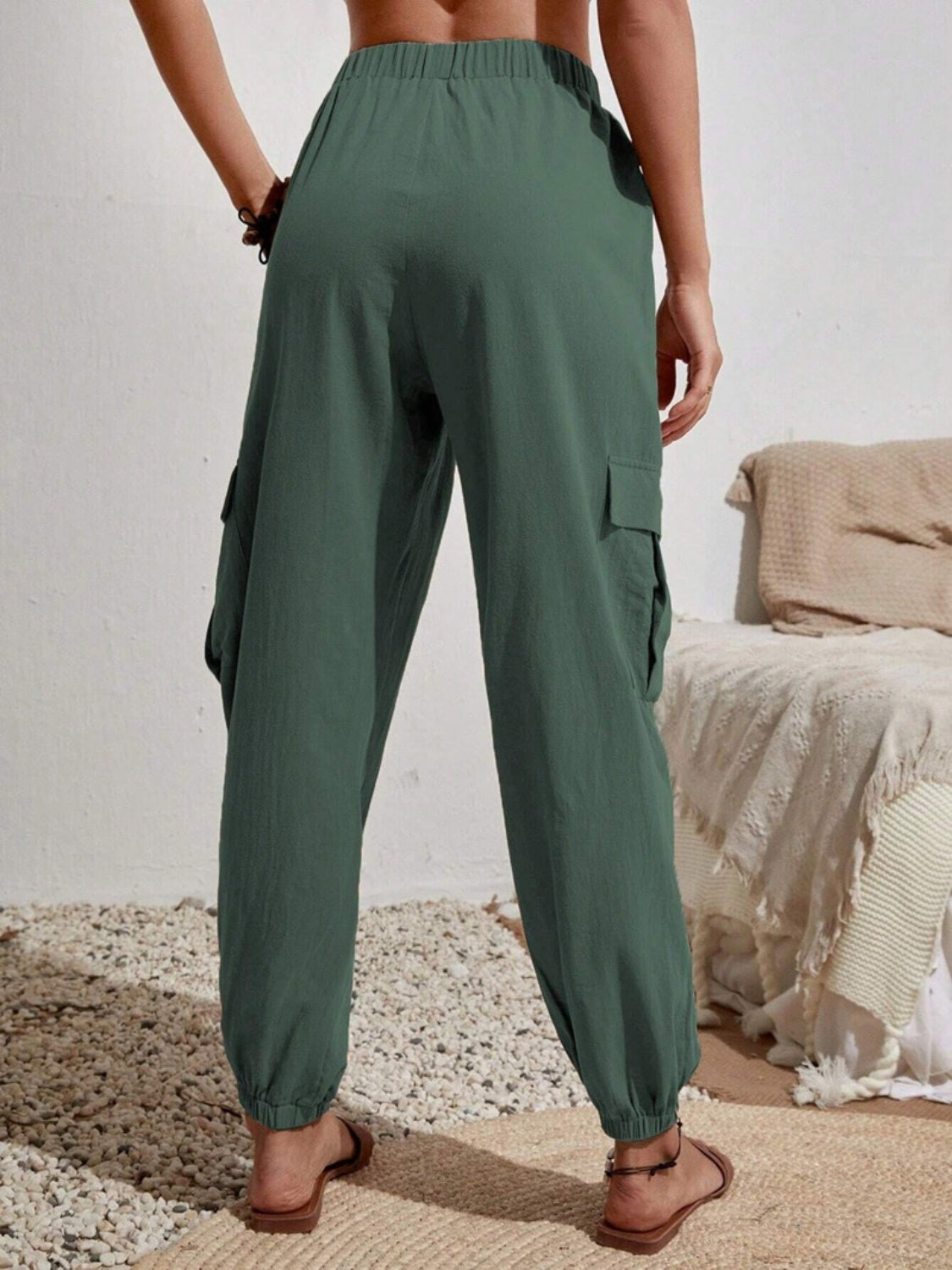 Textured dark green cargo lounge trousers with elastic waist and cuffs, and side pockets.