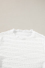 White textured long sleeve top with ruffle trim neckline and smocked fabric detail