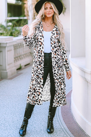 Leopard print duster cardigan with pockets and long sleeves, styled open over a white top and black pants.