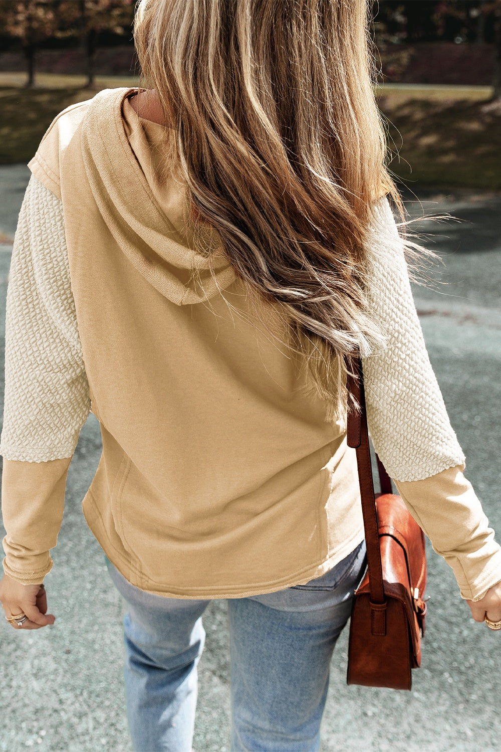 Tan hoodie with textured cream sleeves and a hood.
