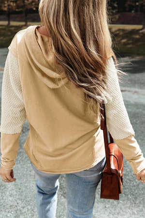 Tan hoodie with textured cream sleeves and a hood.