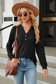 Black waffle knit long sleeve top with button henley neckline.