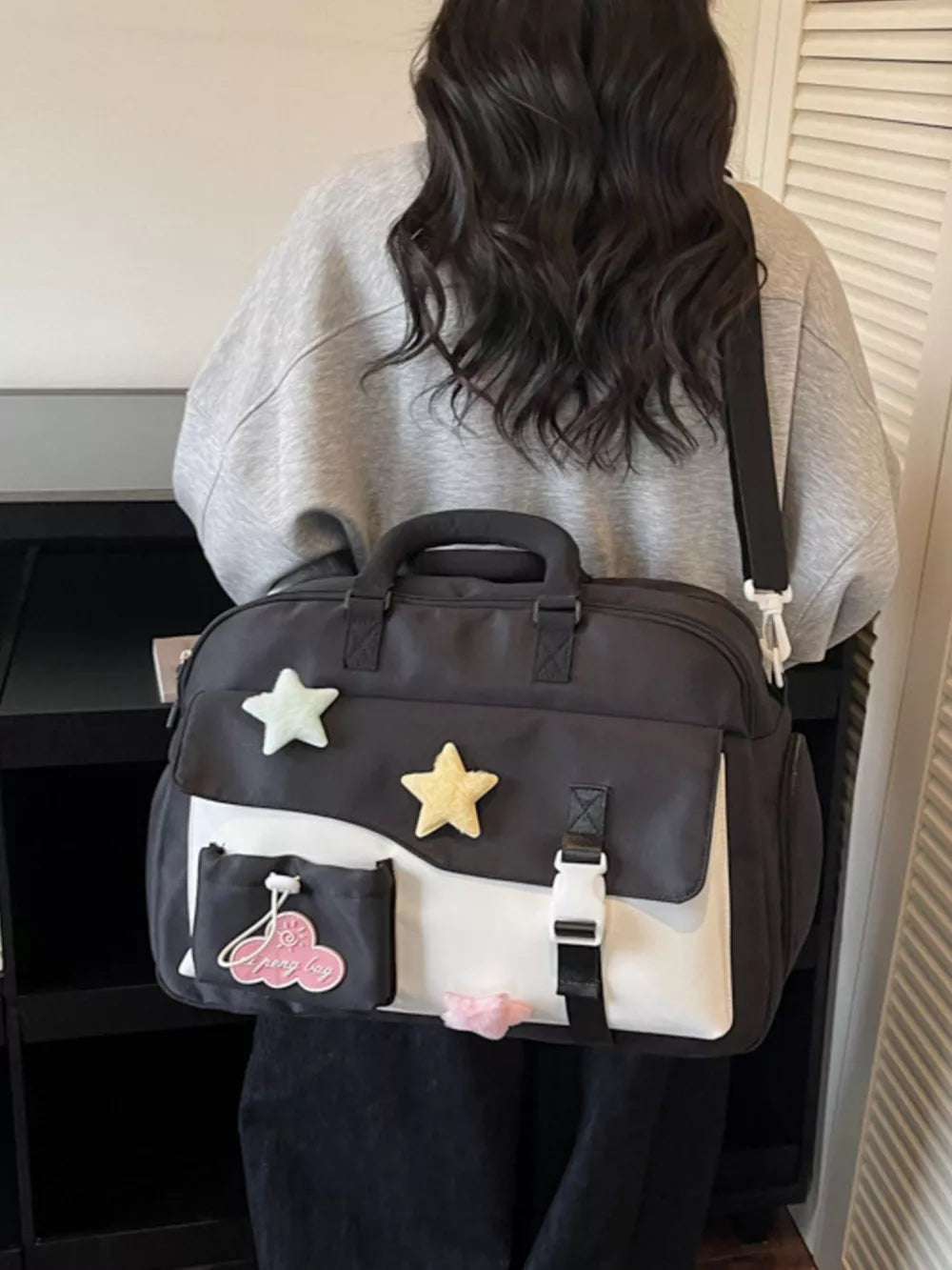 Chic color block travel bag with star embellishments and cloud patch.