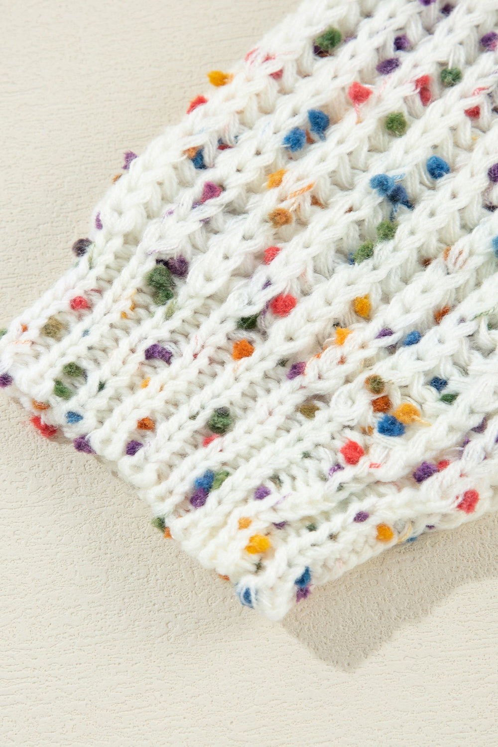 White confetti knit sweater with textured stitch detail and colorful speckles.