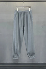 Gray relaxed fit drawstring sweatpants with elastic cuffs and side pockets.
