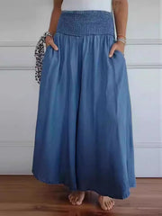 Smocked waistline flow trousers in dusty blue with pockets, wide leg, and frayed hem.