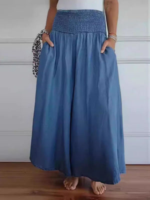 Smocked waistline flow trousers in dusty blue with pockets, wide leg, and frayed hem.