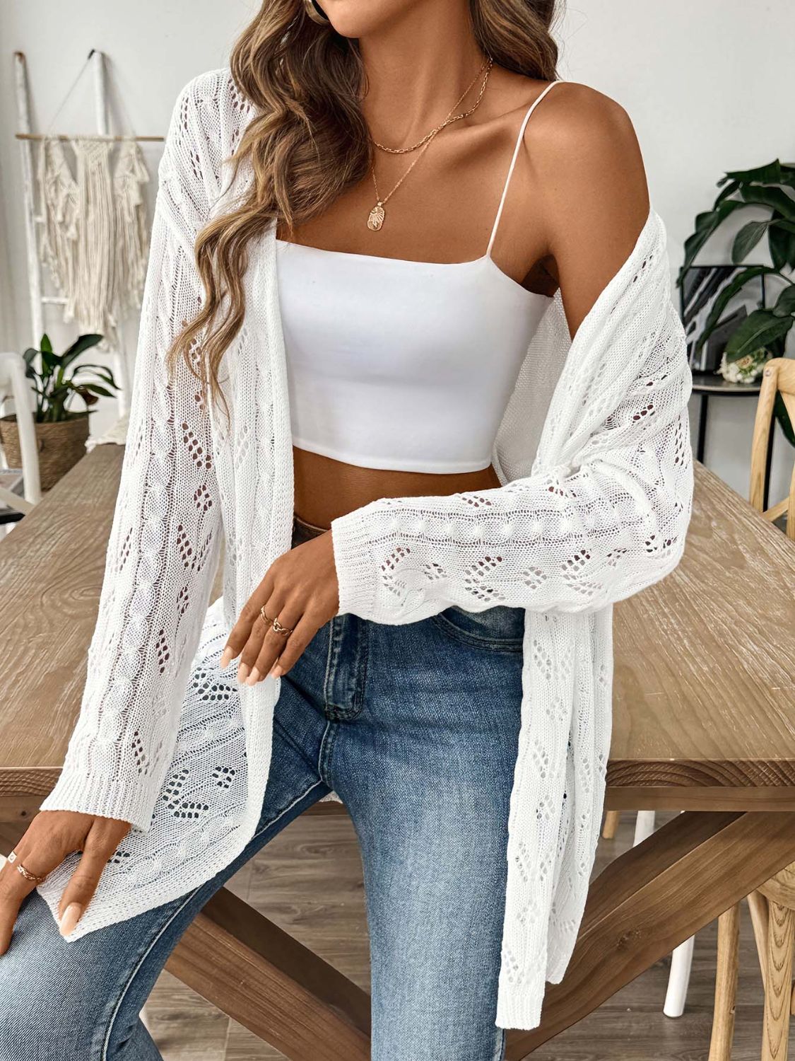 White openwork diamond knit duster cardigan with long sleeves and open front, styled with a white crop top and jeans.