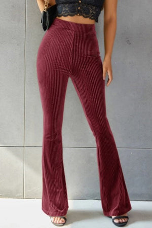 Burgundy ribbed velvet palazzo trousers with a high waist and flared leg.