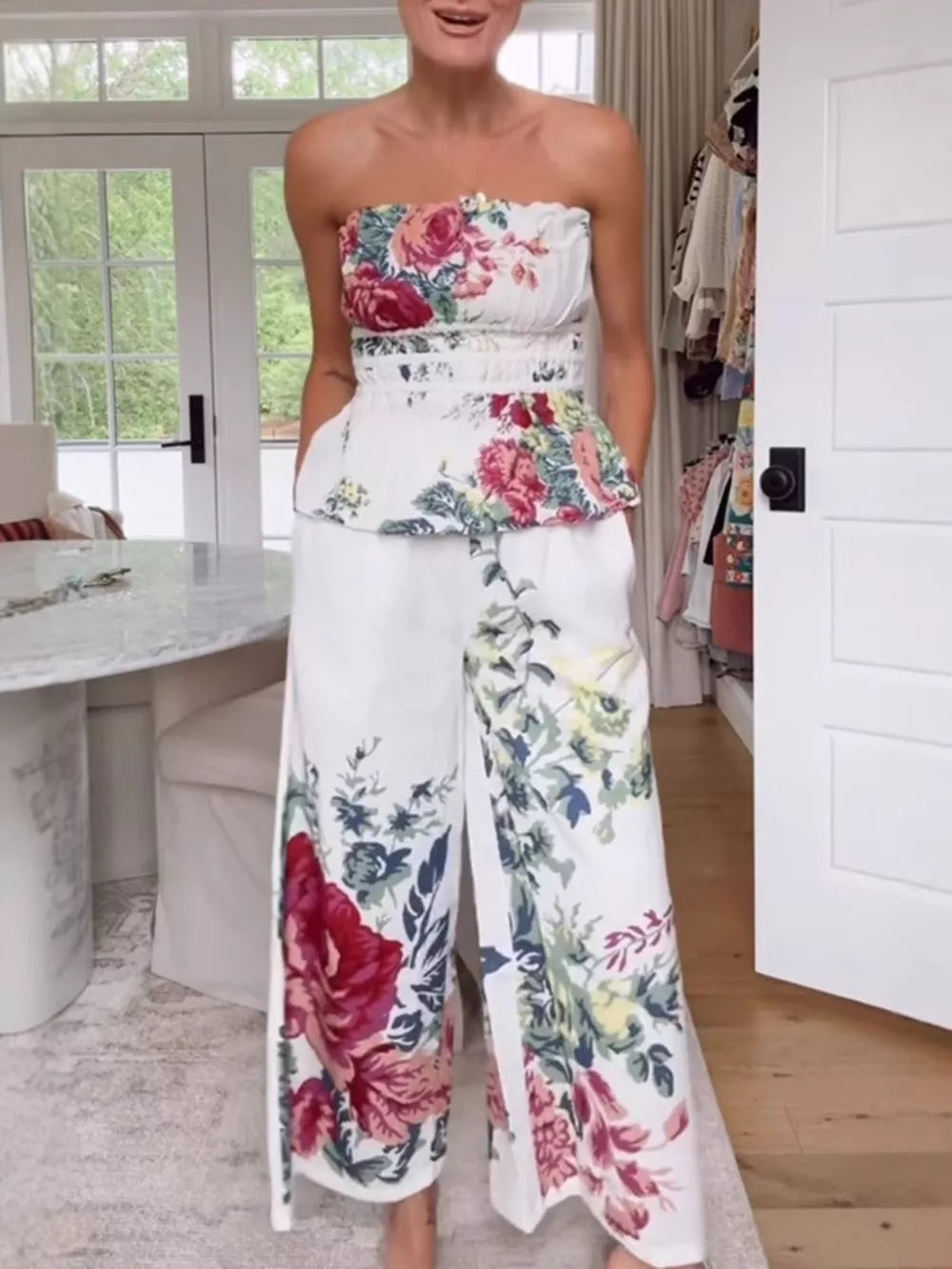 Chic floral ruched strapless top and wide-leg pants set with a peplum hem.