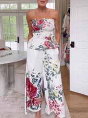 Chic floral ruched strapless top and wide-leg pants set with a peplum hem.
