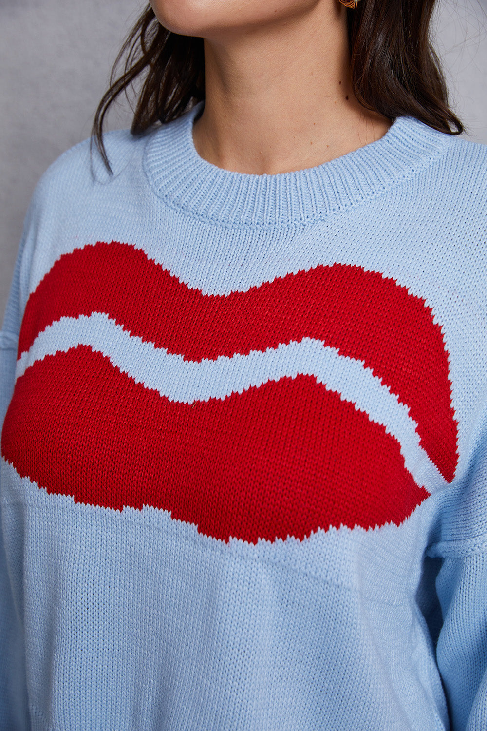 Light blue acrylic knit sweater with a large red kiss graphic and distressed hem.