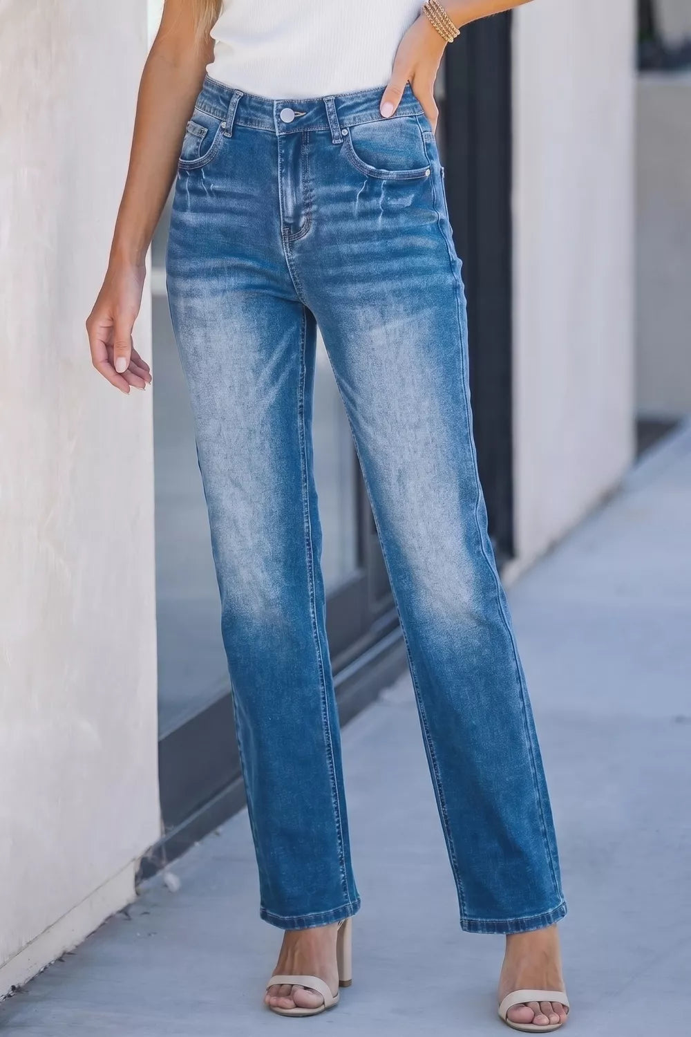 Acid-washed straight-leg denim jeans with a faded blue wash and distressed details.