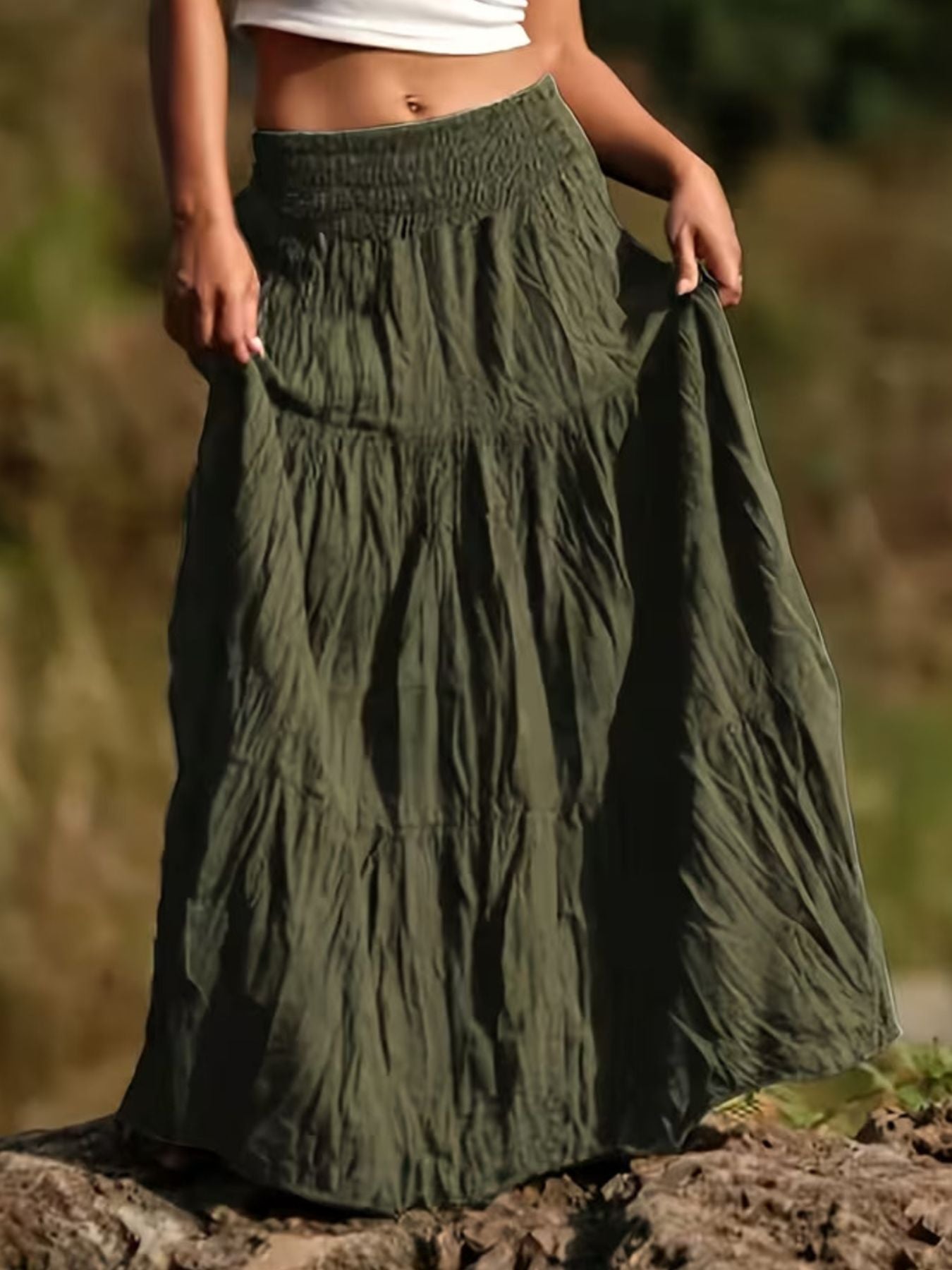 Green tiered maxi skirt with smocked waist and flowing bohemian style.