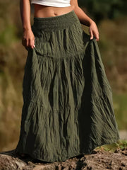 Green tiered maxi skirt with smocked waist and flowing bohemian style.