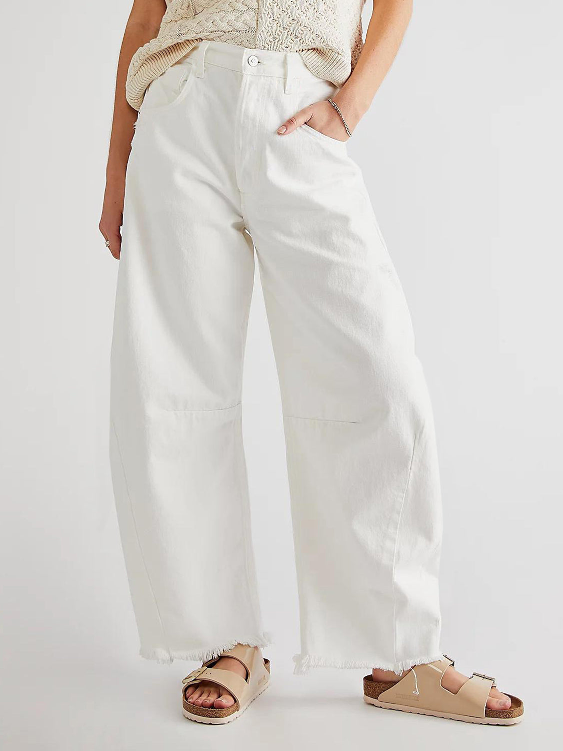 White palazzo jeans with frayed hem and knee panel detail.