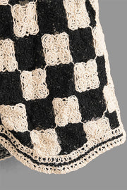 Checkerboard crochet vest in black and cream with floral detail and button front.