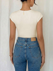 Cream cap sleeve bodysuit with surplice neckline, paired with high-waisted denim jeans.