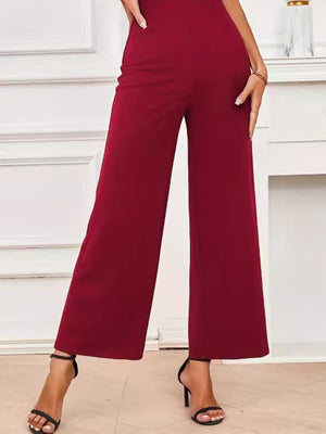 Burgundy wide-leg jumpsuit with a high waist and flowing silhouette.
