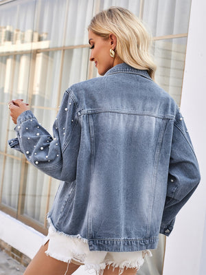 Dusty blue denim jacket with pearl embellishments on sleeves and frayed hem.