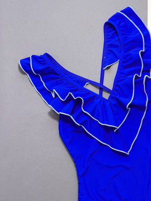 Royal blue ruffled edge cross-back one-piece swimsuit with white trim.