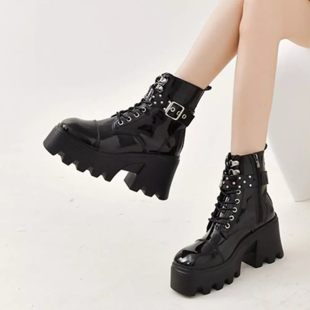 Black glossy platform ankle boots with buckle accents and chunky heel.