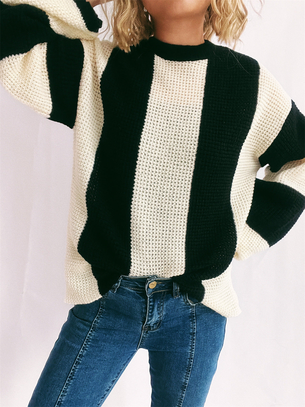 Black and cream vertical stripe waffle knit sweater with crewneck and long sleeves.