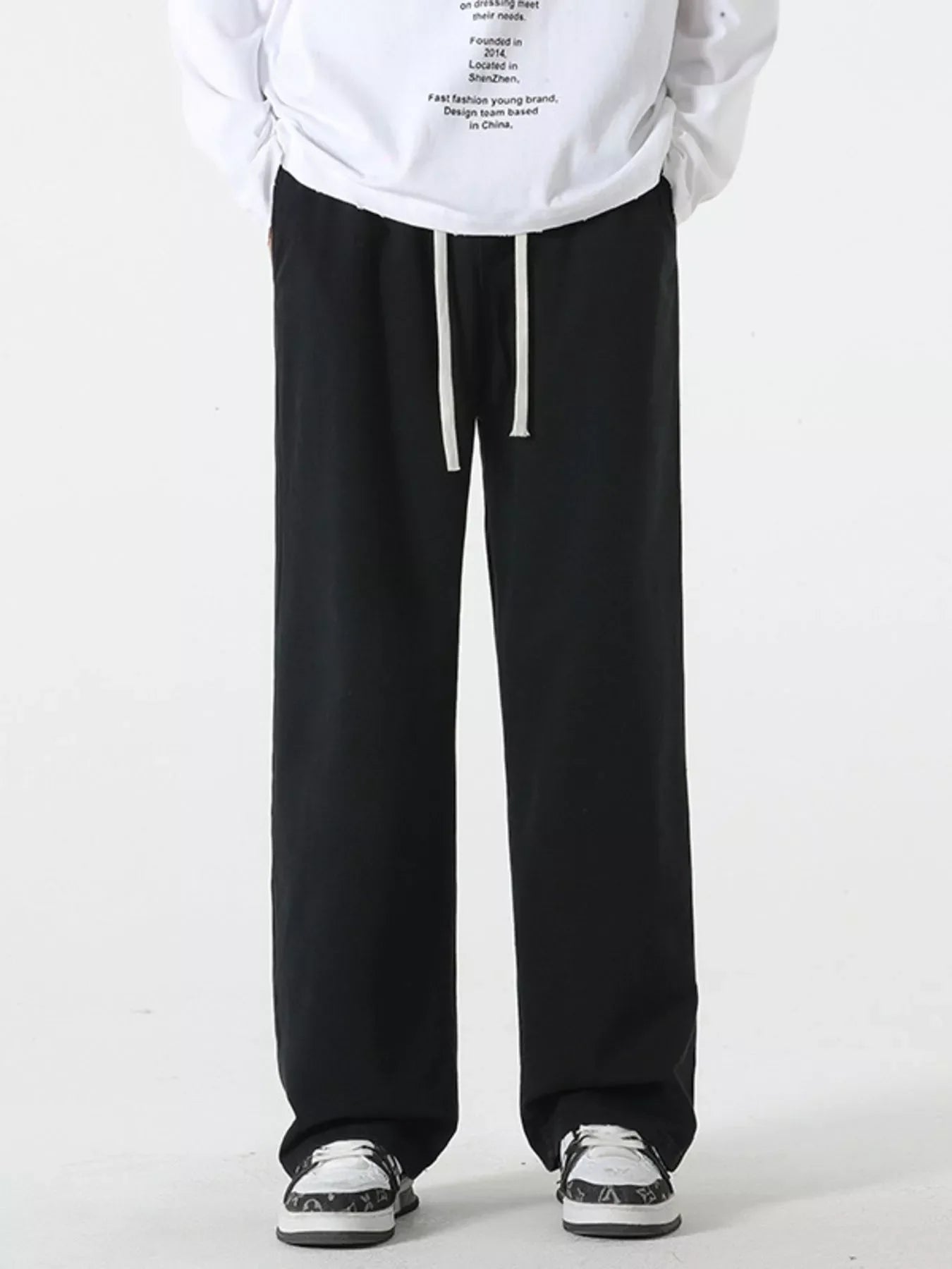 Black relaxed fit drawstring pants with white drawstrings, casual style