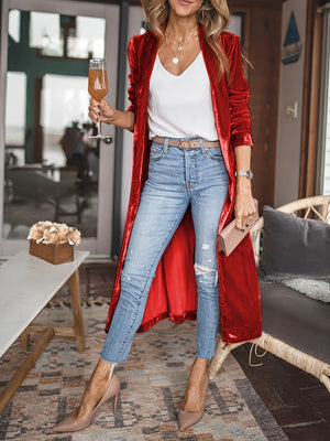 Burgundy velvet duster coat with fluid silhouette, open front, long sleeves, worn with jeans and heels.