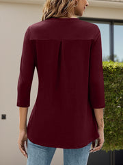 Burgundy three-quarter sleeve top with back pleat detail and V-neck.