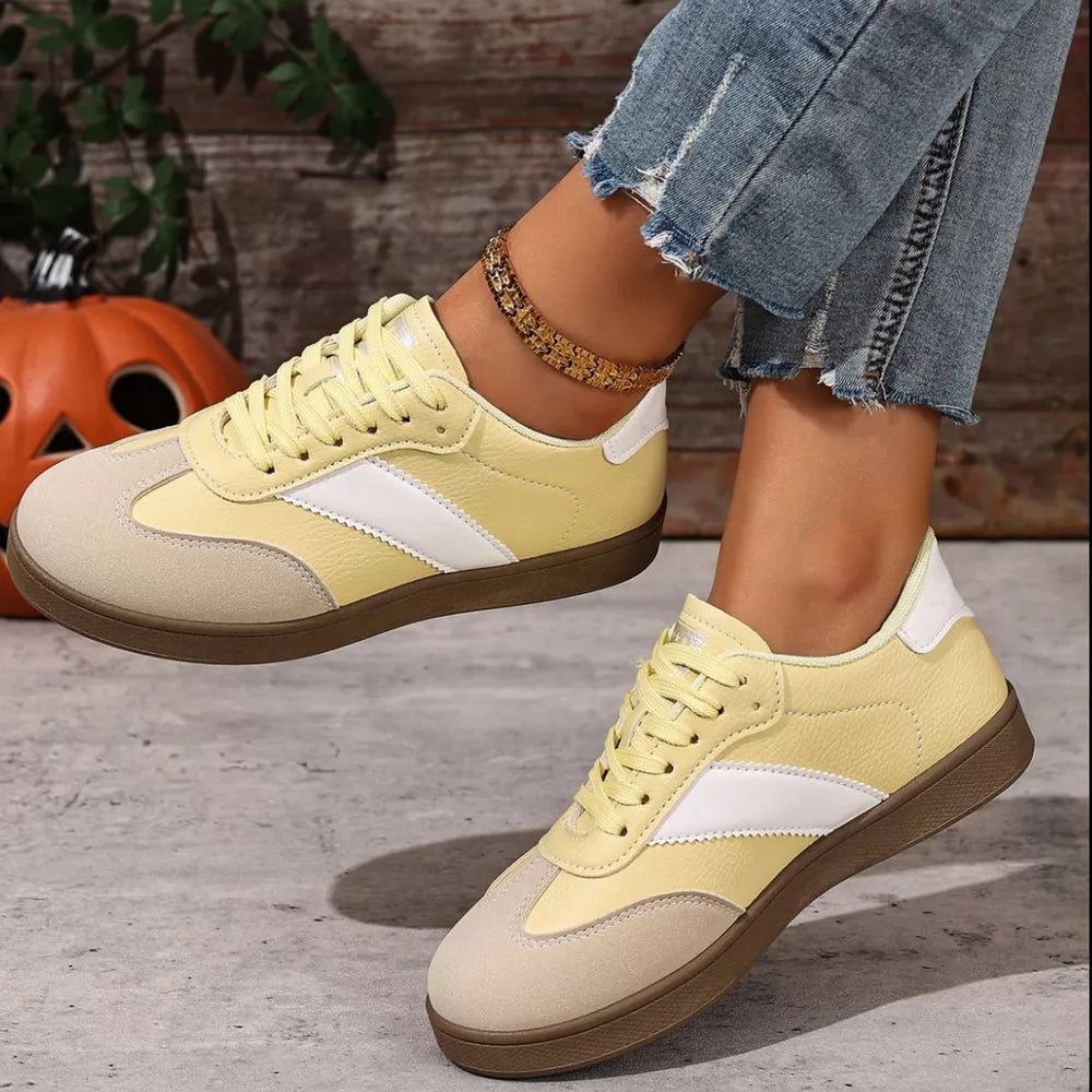 Yellow lace-up sneakers with white and beige accents, suede toe, and brown sole.