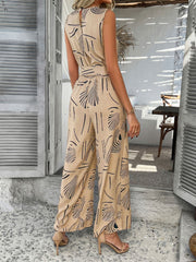 Tan abstract print wide-leg jumpsuit with a belted waist and sleeveless design.