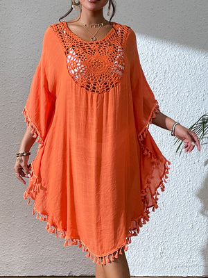 Orange crochet yoke kaftan dress with tassel trim and wide sleeves.